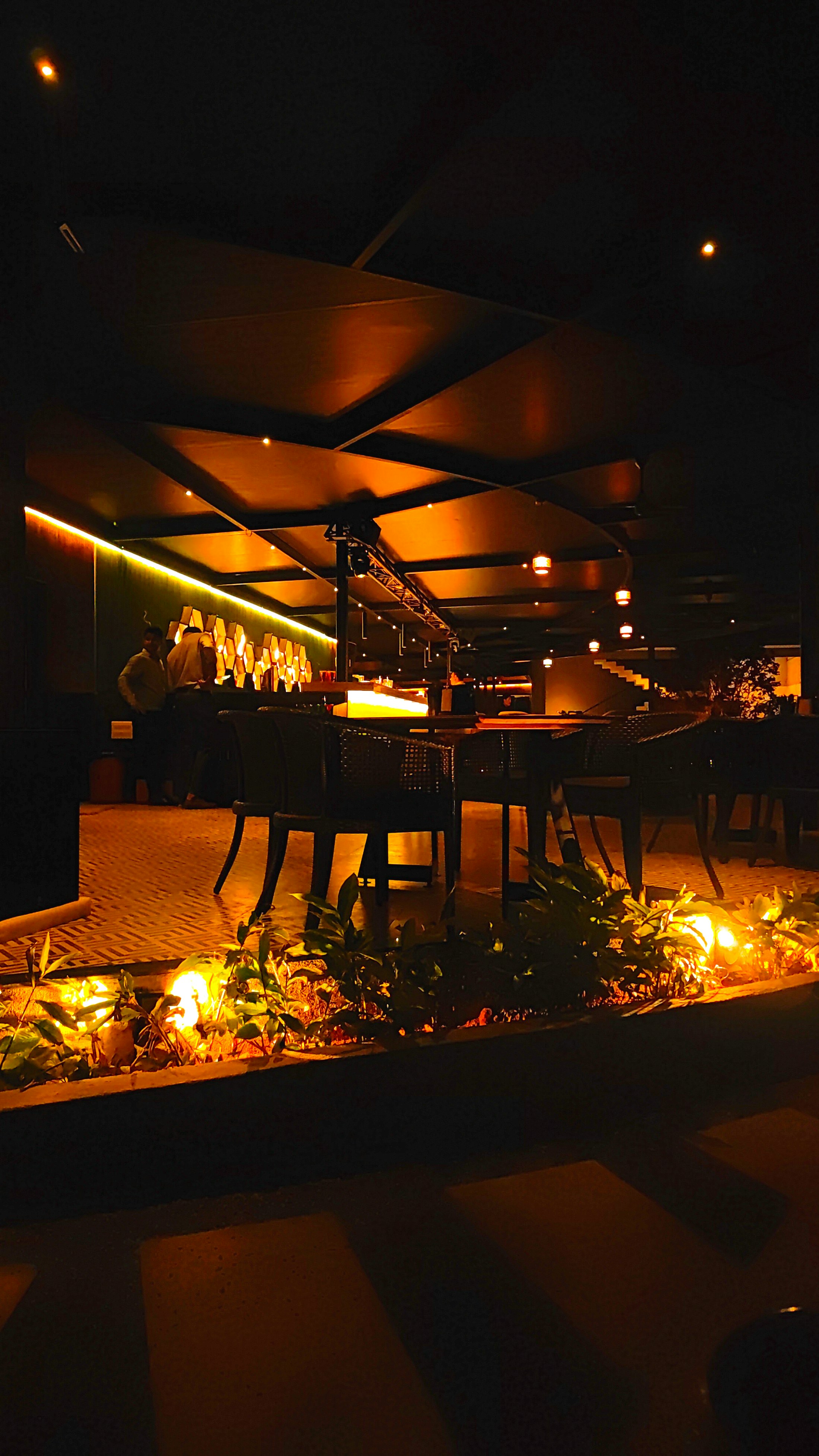 Sıcak ışıklarla aydınlatılmış modern restoran salonu
